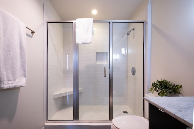 bathroom featuring toilet, vanity, and walk in shower