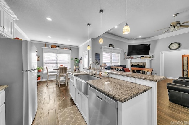 kitchen featuring sink, crown molding, an island with sink, white cabinetry, and stainless steel appliances