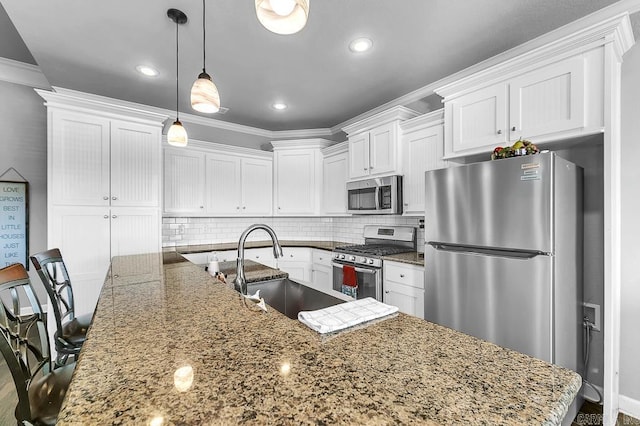 kitchen featuring white cabinetry, sink, stainless steel appliances, backsplash, and decorative light fixtures