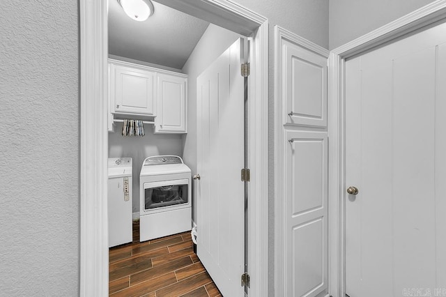 clothes washing area with cabinets and independent washer and dryer