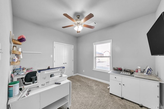 carpeted office featuring ceiling fan