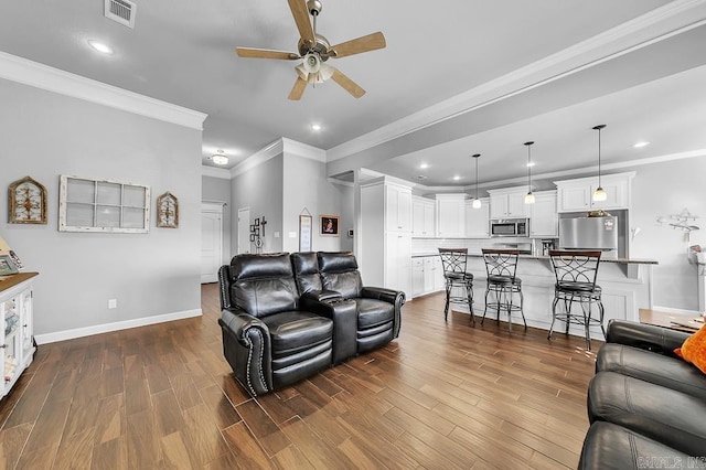 living room with ceiling fan and ornamental molding