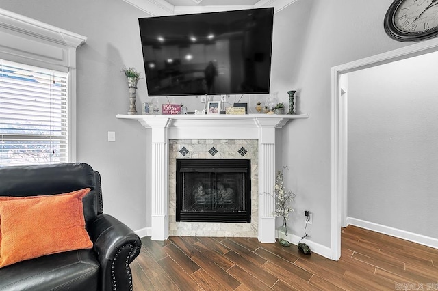 living room with a tiled fireplace and crown molding