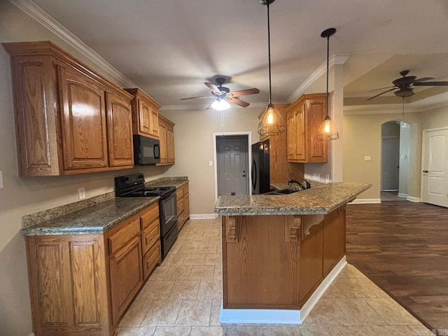 kitchen with kitchen peninsula, pendant lighting, black appliances, and ornamental molding