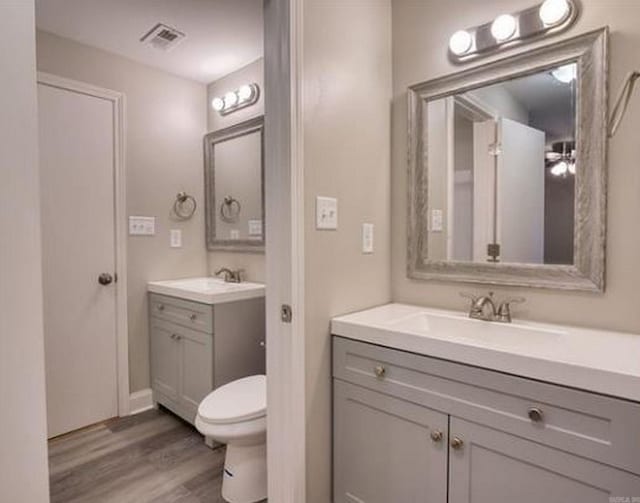 bathroom featuring vanity, toilet, and wood-type flooring