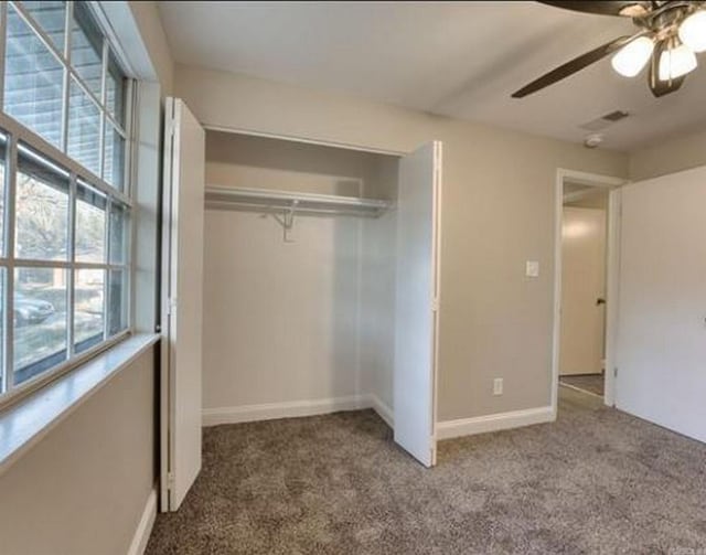 unfurnished bedroom with carpet flooring, a closet, and ceiling fan