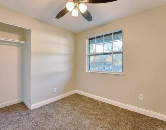 unfurnished bedroom featuring carpet floors, a closet, and ceiling fan