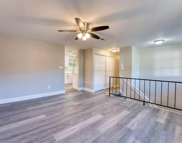 empty room with hardwood / wood-style flooring and ceiling fan