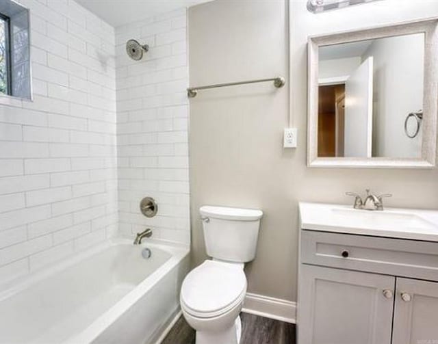 full bathroom with hardwood / wood-style floors, vanity, toilet, and tiled shower / bath