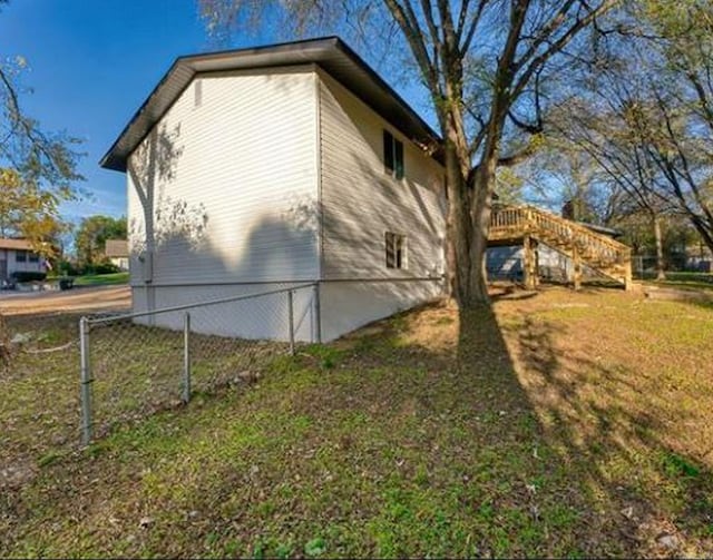 view of home's exterior featuring a lawn and a wooden deck