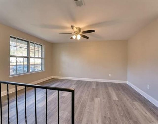 empty room with hardwood / wood-style floors and ceiling fan