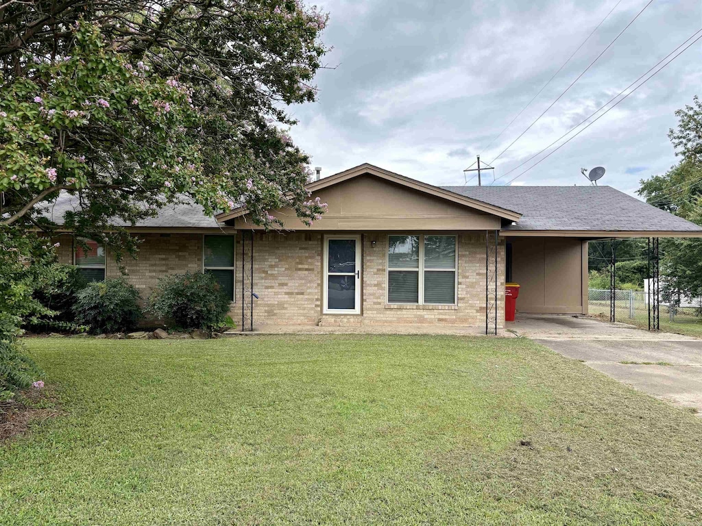 ranch-style house with a front yard and a carport