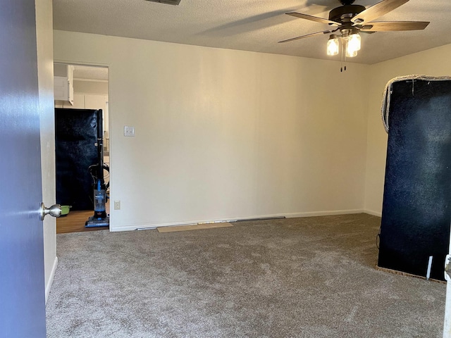 carpeted spare room with a textured ceiling and ceiling fan