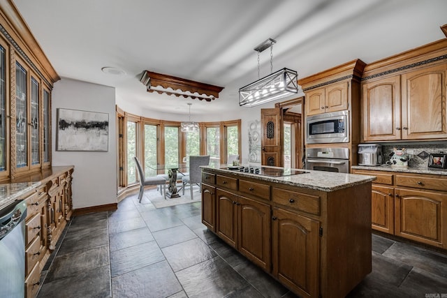 kitchen featuring light stone countertops, french doors, a center island, stainless steel appliances, and decorative light fixtures