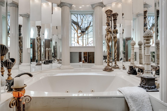 bathroom featuring ornate columns and a tub