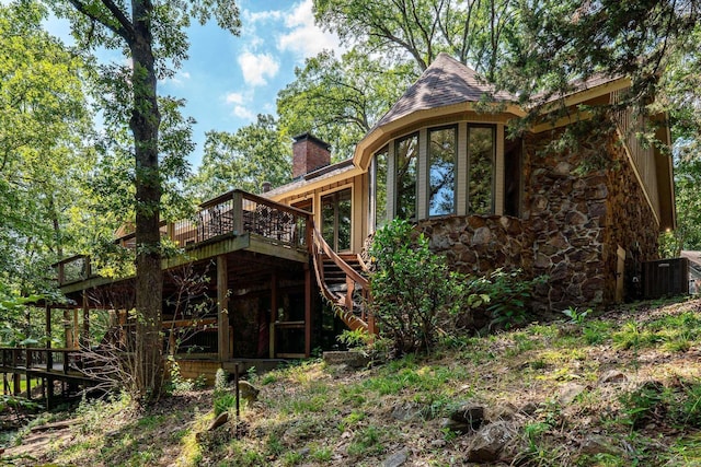 back of house featuring cooling unit and a deck