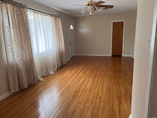 unfurnished room featuring ceiling fan, hardwood / wood-style floors, and a textured ceiling