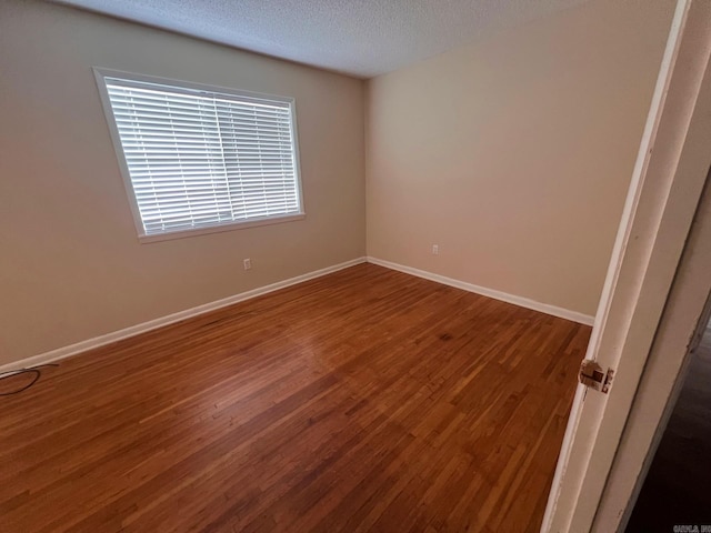 unfurnished room featuring wood-type flooring and a textured ceiling