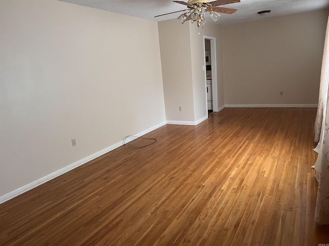 empty room with ceiling fan, wood-type flooring, and a textured ceiling