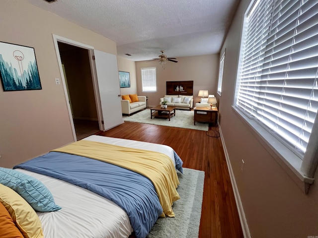 bedroom with wood-type flooring, a textured ceiling, and ceiling fan