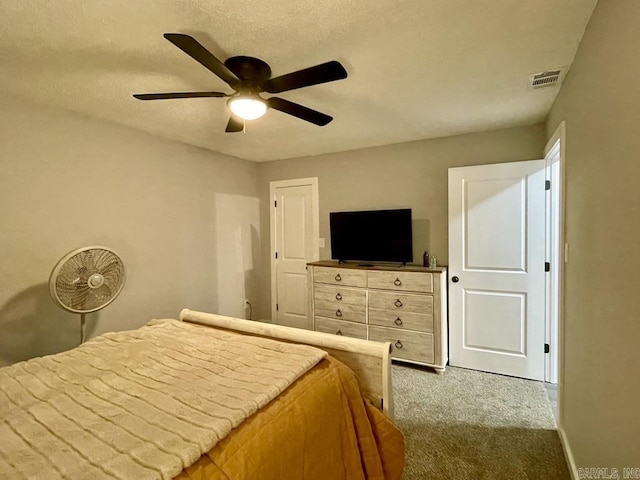 bedroom featuring carpet flooring, ceiling fan, and a textured ceiling