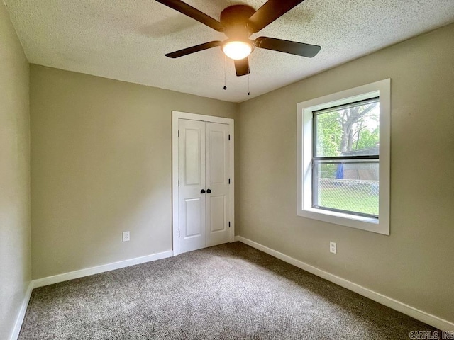 spare room with carpet flooring, ceiling fan, and a textured ceiling