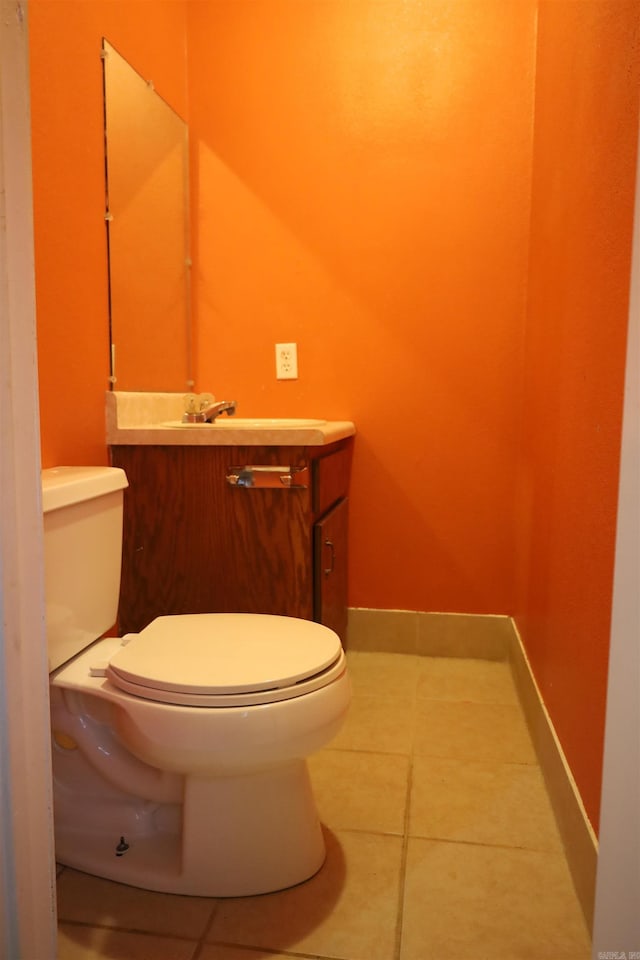 bathroom with tile patterned flooring, vanity, and toilet