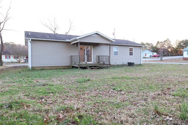 back of house featuring a lawn and central AC unit