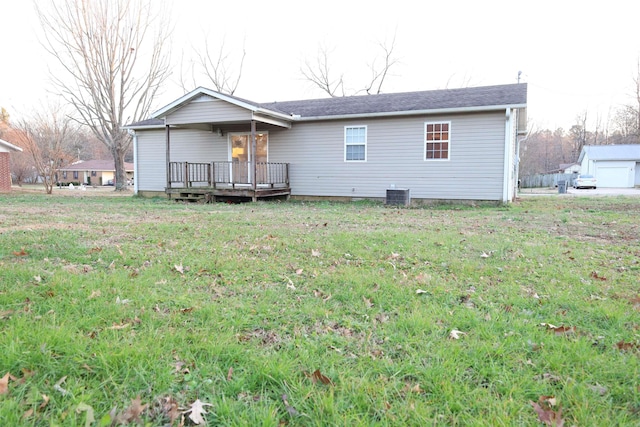 rear view of property featuring a lawn, a deck, and central air condition unit