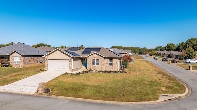 view of front of home featuring a front lawn, a garage, and solar panels