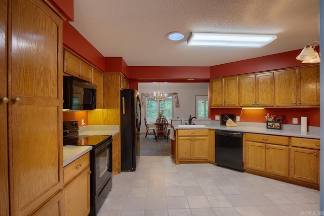 kitchen featuring pendant lighting, black appliances, sink, a textured ceiling, and a notable chandelier