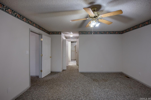 spare room featuring carpet, ceiling fan, and a textured ceiling