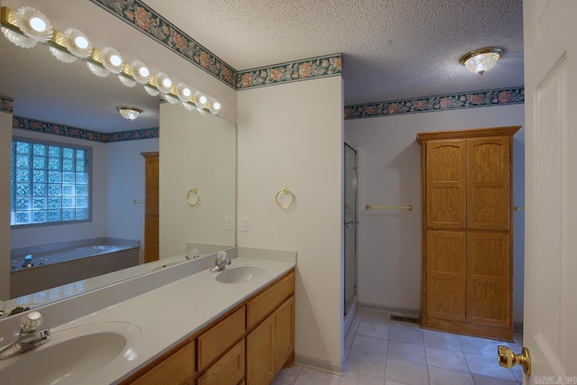 bathroom with tile patterned floors, vanity, independent shower and bath, and a textured ceiling