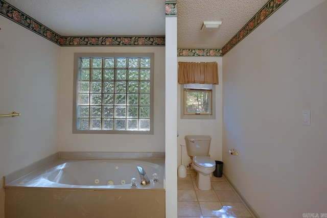 bathroom with a washtub, a textured ceiling, toilet, and tile patterned flooring