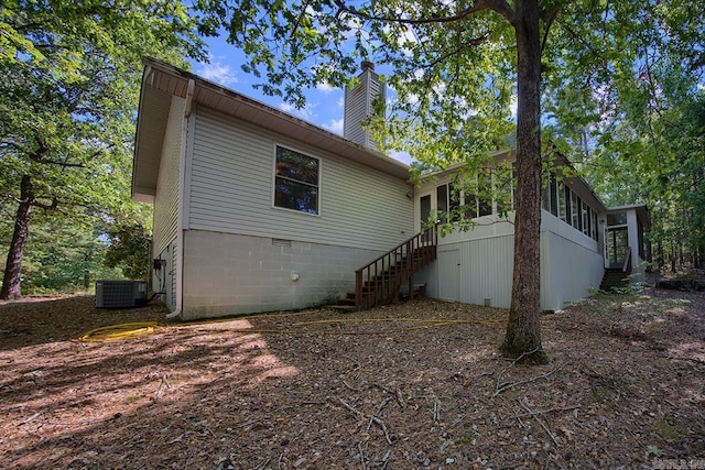 view of side of property with a sunroom and cooling unit