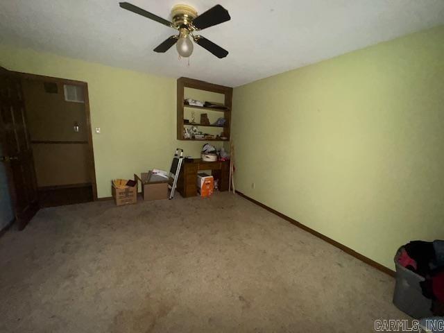 interior space with carpet flooring and ceiling fan