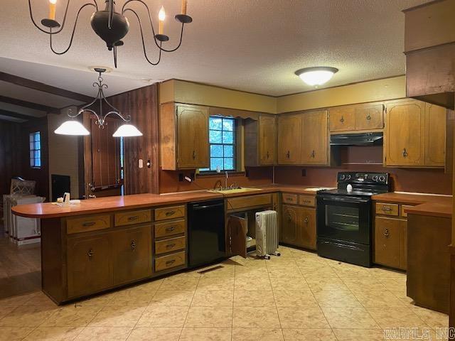 kitchen featuring kitchen peninsula, sink, black appliances, decorative light fixtures, and a chandelier