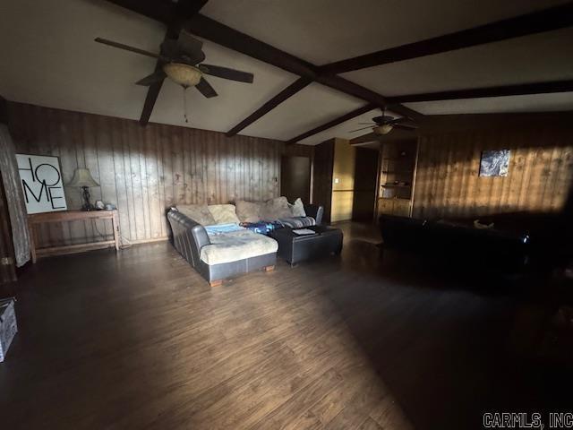 bedroom with vaulted ceiling with beams, wood walls, and dark wood-type flooring