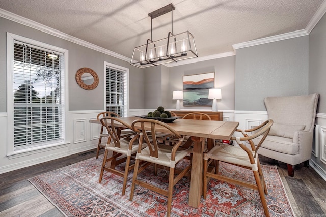 dining space featuring a textured ceiling, dark hardwood / wood-style flooring, crown molding, and an inviting chandelier