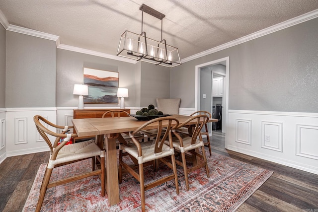 dining space featuring a notable chandelier, dark hardwood / wood-style flooring, a textured ceiling, and ornamental molding