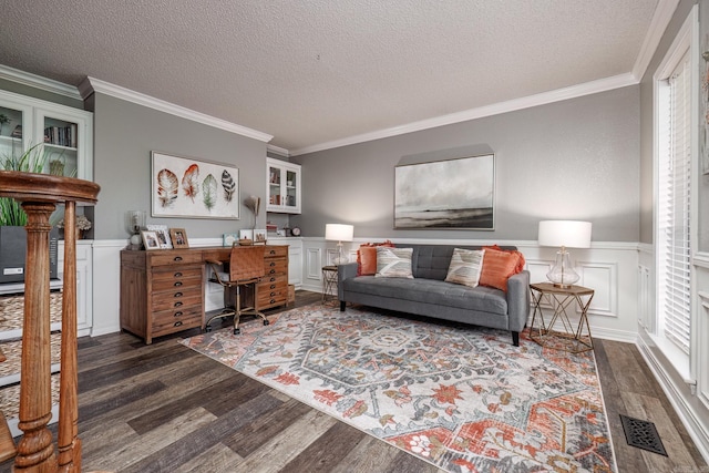 living room with dark hardwood / wood-style flooring, a healthy amount of sunlight, a textured ceiling, and ornamental molding