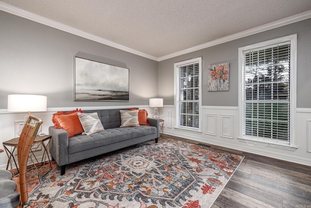 living room with hardwood / wood-style floors, a textured ceiling, and ornamental molding