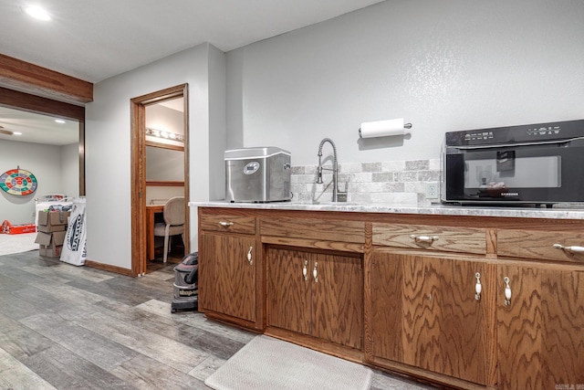 kitchen with light hardwood / wood-style flooring, oven, and sink