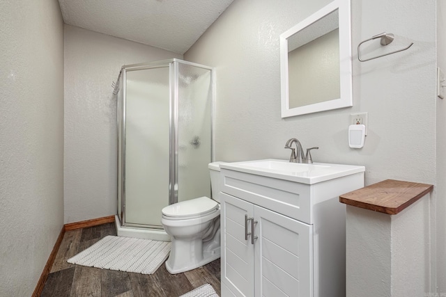 bathroom with an enclosed shower, vanity, a textured ceiling, hardwood / wood-style floors, and toilet