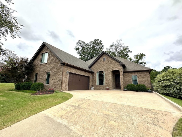 french country style house featuring a garage and a front lawn