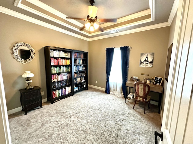 office with carpet flooring, ceiling fan, a raised ceiling, and ornamental molding