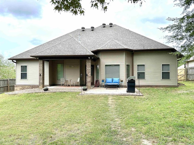 rear view of property featuring a patio area, an outdoor living space, and a yard