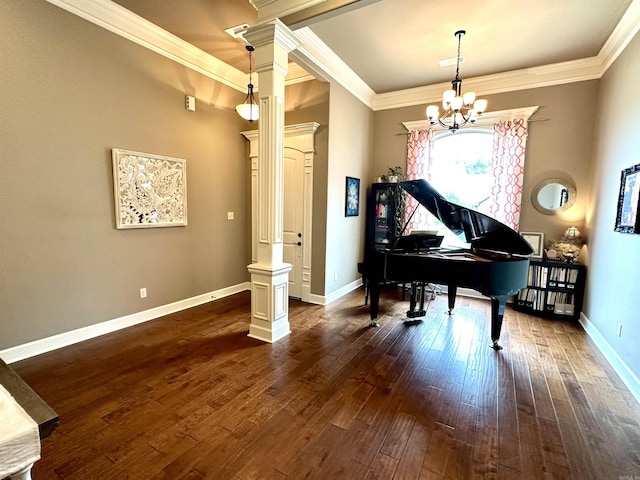 miscellaneous room featuring dark hardwood / wood-style flooring, ornate columns, ornamental molding, and an inviting chandelier