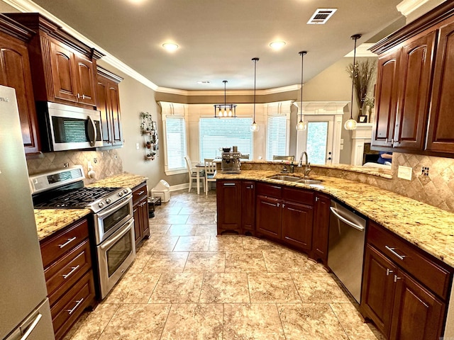 kitchen with hanging light fixtures, tasteful backsplash, sink, and stainless steel appliances