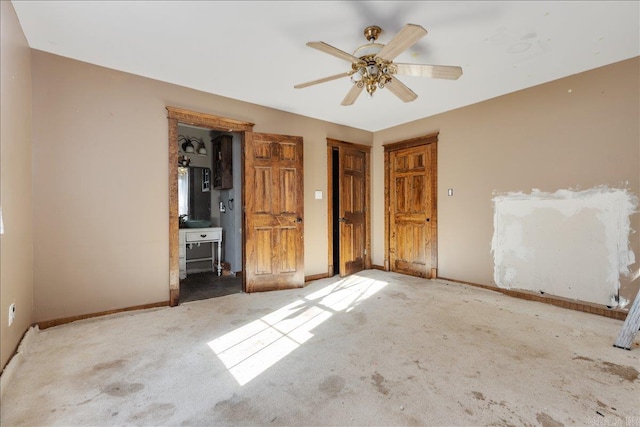 unfurnished bedroom with ensuite bath, ceiling fan, and light carpet